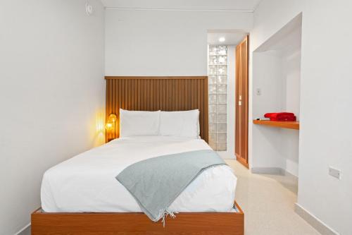 a bedroom with a large bed with a wooden headboard at Ayana Inn PR in San Juan