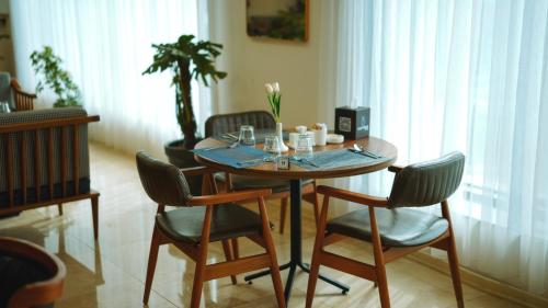 a dining room table with chairs and a table and a plant at Blue Moon Hotel in Erbil