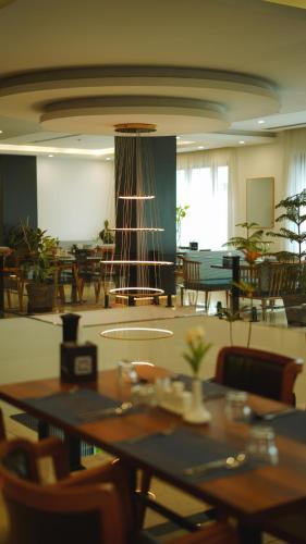 a dining room with tables and chairs and a chandelier at Blue Moon Hotel in Erbil