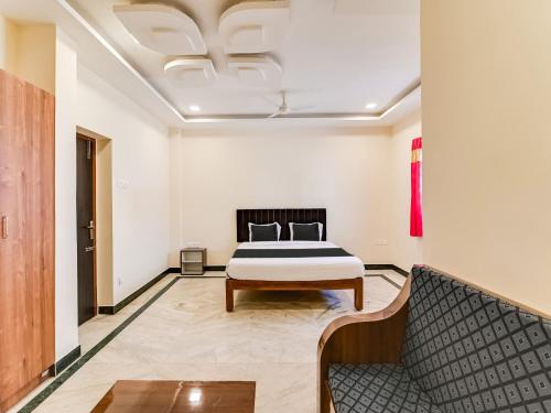 a bedroom with a bed and a couch at Hotel O Rj Royal Inn in Vellore