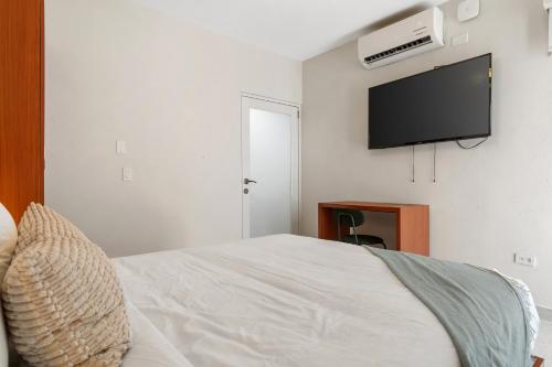 a bedroom with a bed and a flat screen tv at Ayana Inn PR in San Juan
