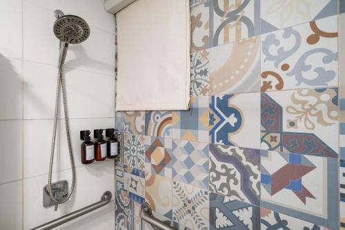 a bathroom with a shower with colorful tiles at Ayana Inn PR in San Juan