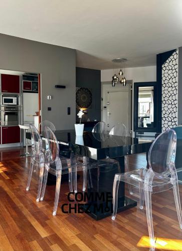 une salle à manger avec une table et des chaises en verre dans l'établissement Le Balcon de l'Excelsior avec parking, à Nancy