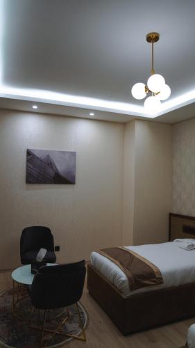 a bedroom with a bed and a table and a chair at Blue Moon Hotel in Erbil