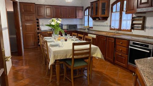 a kitchen with a table with a vase of flowers on it at Quinta da Barrosa in Tentúgal