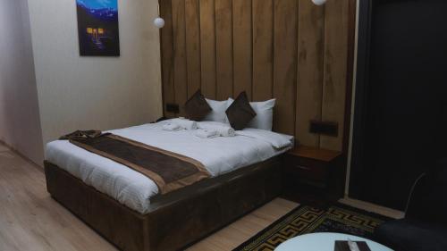 a bedroom with a bed with towels on it at Blue Moon Hotel in Erbil