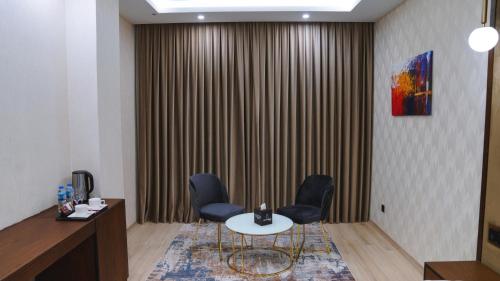 a meeting room with a table and chairs and a wall at Blue Moon Hotel in Erbil