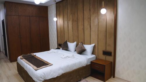 a bedroom with a large bed and a wooden wall at Blue Moon Hotel in Erbil
