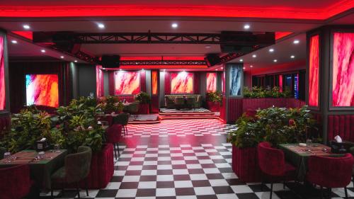 a room with red lighting and a checkered floor at Blue Moon Hotel in Erbil