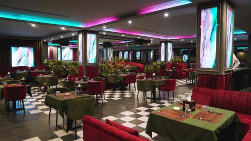 a restaurant with tables and chairs in a room at Blue Moon Hotel in Erbil
