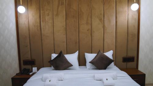 a bedroom with a large bed with white sheets and pillows at Blue Moon Hotel in Erbil