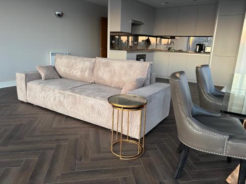 ロンドンにあるExcel Luxury Apartment with amazing viewのソファとテーブルと椅子のあるリビングルーム