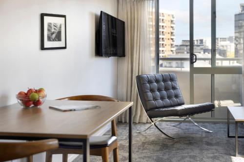 un salon avec une table et une chaise dans l'établissement Quest Auckland Serviced Apartments, à Auckland