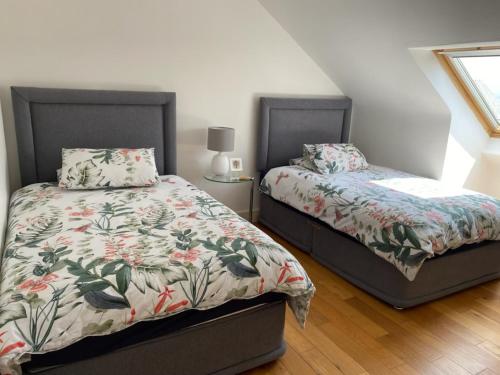 two beds sitting next to each other in a bedroom at Beach House Inch in Inch