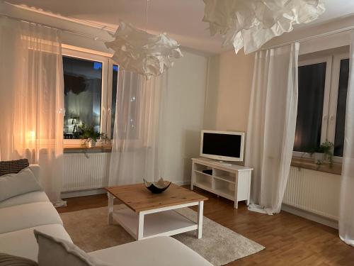 salon z białą kanapą i telewizorem w obiekcie Apartament w kamienicy Gdynia w mieście Gdynia