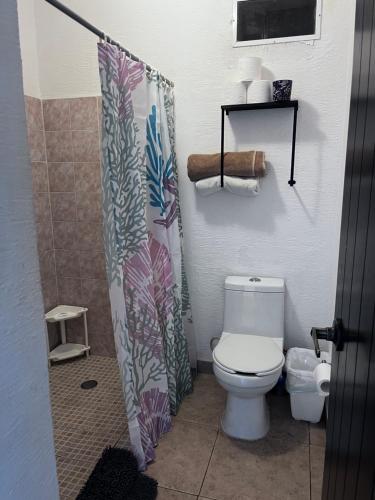 a bathroom with a toilet and a shower curtain at Great price on the beach in Cancún