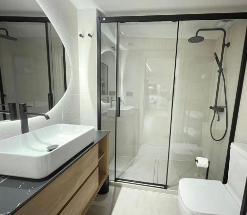 a bathroom with a sink and a glass shower at Exclusivo Apartamento en el centro de Murcia in Murcia