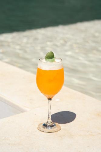 a glass of beer sitting on a table next to the water at Wao Beach Venao in Playa Venao