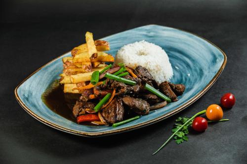 a blue plate of food with rice and meat at Quechua Hotel Cusco in Cusco
