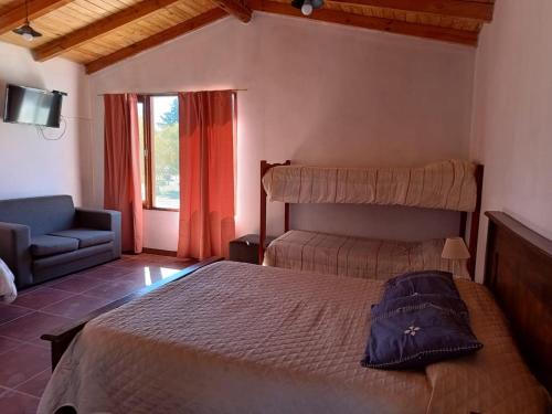 a bedroom with a bed and a chair and a window at Departamentos Complejo Turístico Cruz Mendoza in Tilcara