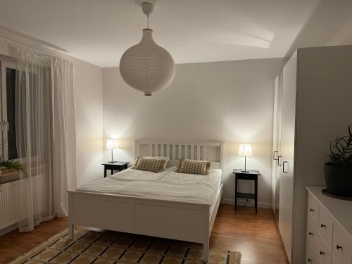 biała sypialnia z łóżkiem i 2 szafkami nocnymi w obiekcie Apartament w kamienicy Gdynia w mieście Gdynia