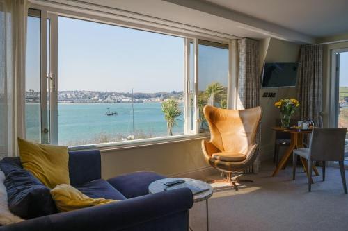 a living room with a blue couch and a large window at Bijou Beachfront Gem, Rock in Padstow