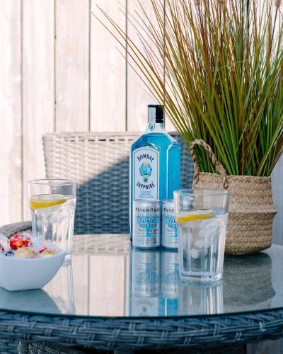 a bottle of water and two glasses on a table at Bijou Beachfront Gem, Rock in Padstow