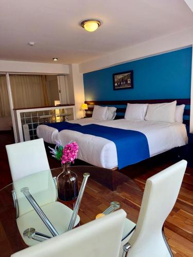 a bedroom with a large bed and a table and chairs at Wayqey Hotel in Cusco