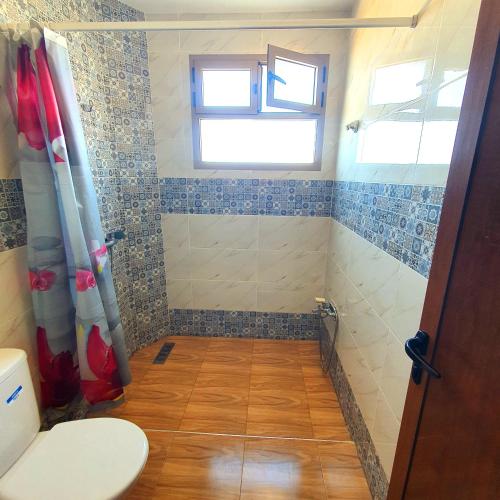 a small bathroom with a toilet and a window at The View in Taghazout