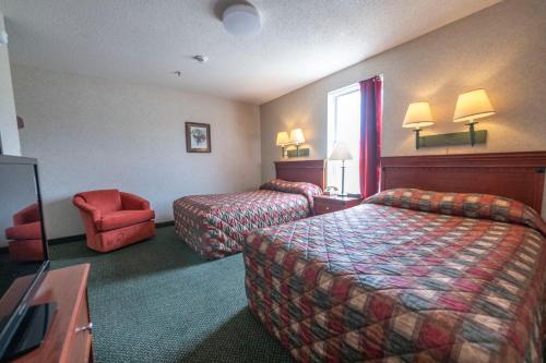 a hotel room with two beds and a chair at Santa's Lodge in Santa Claus