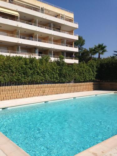 une piscine devant un immeuble dans l'établissement Appartement toit terrasse Nice-ouest avec parking, clim et piscine, à Nice