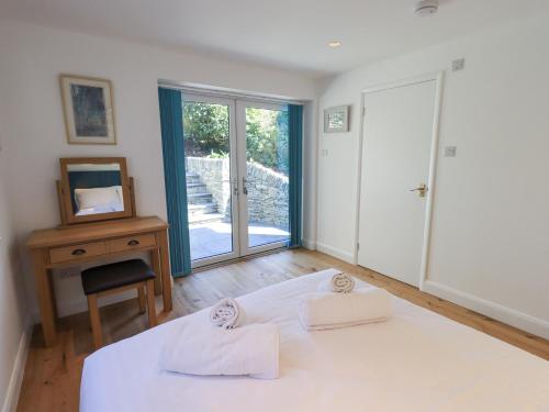 a bedroom with a bed and a desk and a window at Striding Home in Ambleside
