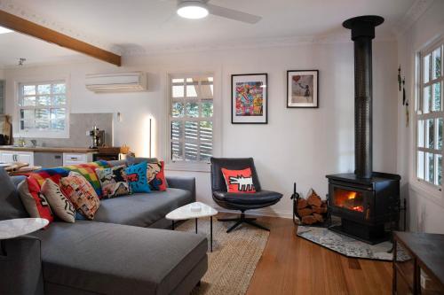 a living room with a couch and a stove at Wrenwood Cottage- outdoor spa in serene setting in Daylesford