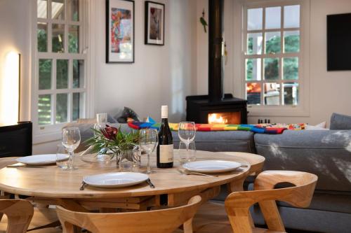 a table with a bottle of wine and glasses at Wrenwood Cottage- outdoor spa in serene setting in Daylesford