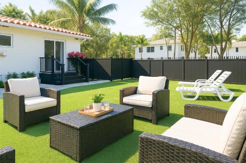 a patio with wicker chairs and a table on grass at Central Miami Oasis, Near Brickell, Grove & Little Havana in Miami
