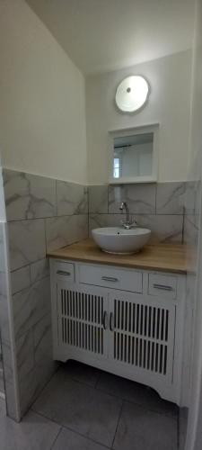 une salle de bain avec un lavabo et un miroir dans l'établissement Studio centre ville de Gagny, à Gagny