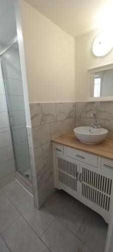 une salle de bain blanche avec un lavabo et une douche dans l'établissement Studio centre ville de Gagny, à Gagny