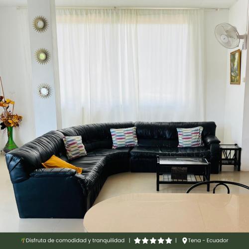 a black leather couch in a living room at RinaKawsay - ViveViajando Apartamento amoblado en Tena in Tena
