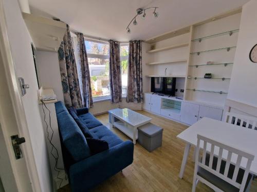 a living room with a blue couch and a table at Cosy Apartment in North London - Great Location in London