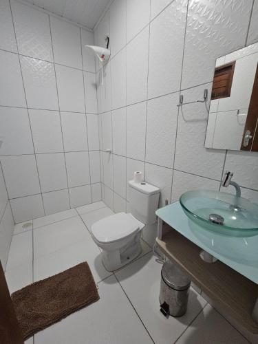 a white bathroom with a toilet and a sink at Suítes Milagres Bontempo in São Miguel dos Milagres