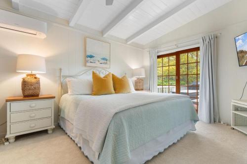 a white bedroom with a bed and a window at Private Pool and Just a 3 Minute Walk to the Beach in Pawleys Island