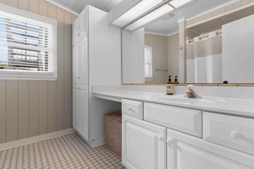 a white bathroom with a sink and a mirror at Private Pool and Just a 3 Minute Walk to the Beach in Pawleys Island