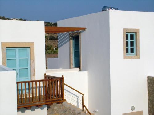 a white house with a staircase and a balcony at Villa Patmos Netia in Patmos