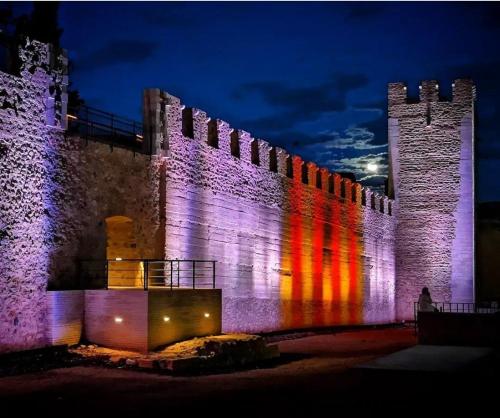 a castle is lit up with purple and red lights at Cal Capdevila in Pira