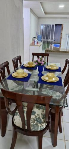 a dining room table with yellow dishes on it at Casa com piscina em Itamaracá in Itamaracá