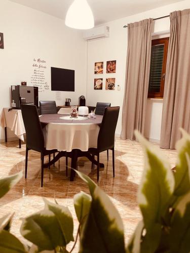 a dining room with a table and chairs and a television at La casa dei nonni in San Salvo