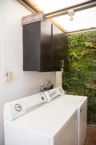 a bathroom with a white sink and a laundry room at Life Hospitality in Ensenada