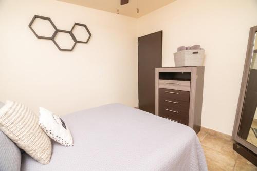 a bedroom with a white bed and a dresser at Life Hospitality in Ensenada
