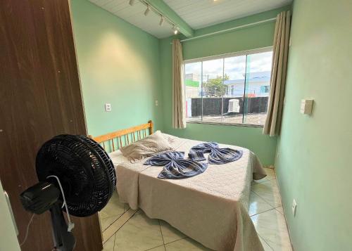 a bedroom with a bed with blue sheets and a window at Ramos Residence - AP101 in Navegantes