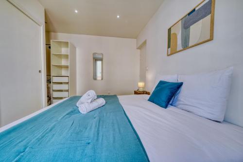 Un dormitorio con una cama azul con toallas. en Le Joyau, en Reims